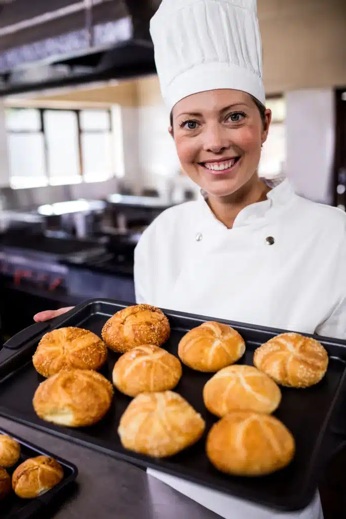 About About female chefs holding baking tray of kaiser rolls i 2025 04 04 11 05 06 utc